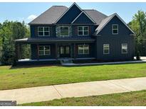 Beautiful two-story home featuring a covered porch, stone accents, and a well-manicured lawn at 5484 Two Hills Dr # 32, Fairburn, GA 30213