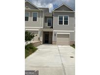 Charming townhome with attached garage, modern siding, and concrete driveway at 6116 Ripple Way # 47, South Fulton, GA 30349