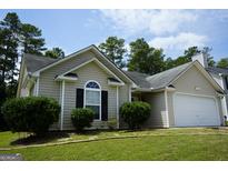 Charming one-story home with a manicured front yard and attached garage in a suburban neighborhood at 207 Millwheel Dr, Villa Rica, GA 30180