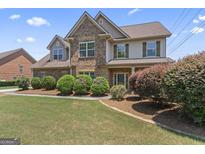 Charming two-story home featuring a brick facade, landscaped front yard, and welcoming entrance at 100 Belgian Ct, Hampton, GA 30228