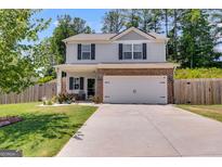 Charming two-story home featuring a two-car garage and a well-manicured lawn at 1018 Nandina Ct, Villa Rica, GA 30180