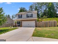 Charming two-story home with a brick-accented garage, a well-maintained lawn, and a driveway at 1018 Nandina Ct, Villa Rica, GA 30180