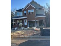 Two-story brick home with an unfinished lawn and two-car garage, featuring a gray siding exterior at 257 Orwell Dr # 48, Social Circle, GA 30025
