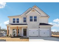 Charming two-story home featuring a brick facade, a two-car garage, and a covered front porch at 358 Orwell Dr # 94, Social Circle, GA 30025