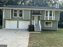 Two-story house with green siding, white garage doors, and a landscaped yard at 2961 Forelock Sw Pl, Marietta, GA 30064