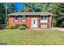 Charming brick home featuring well-maintained landscaping, black shutters, and a welcoming front entrance at 6671 Pelica Ct, Riverdale, GA 30274