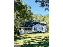 Charming one-story house with a wraparound porch and landscaped lawn at 4755 Jersey Walnut Grove Rd, Covington, GA 30014