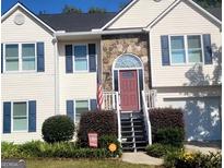 Two-story house featuring a stone facade and a red front door at 3870 Michaels Creek Ct, Loganville, GA 30052