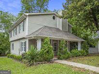 Two-story house with gray siding, a covered porch, and well-manicured landscaping at 1326 Mcpherson Se Ave, Atlanta, GA 30316