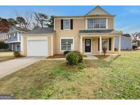 Two-story house with beige siding, attached garage, and landscaping at 6235 Marbut Farms Trl, Lithonia, GA 30058