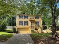 Two-story yellow house with a garage and landscaping at 435 Ridgedale Way, Lawrenceville, GA 30044