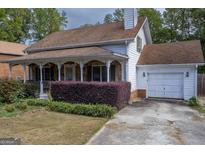 Charming two-story home with a stone porch and a well-manicured garden in front at 2884 Mountbery Dr, Snellville, GA 30039