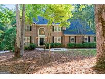 Traditional brick home with a manicured lawn and mature trees in a beautiful wooded neighborhood at 270 Emerald Lake Dr, Fayetteville, GA 30215