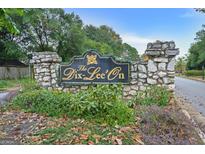 Stone community sign for The Dix-Lee'on neighborhood, surrounded by greenery and mature trees at 470 Dix Lee On Dr, Fayetteville, GA 30214