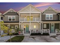Charming two-story townhome featuring double balconies, a teal front door and welcoming front porch at 14020 Tributary Ln, Villa Rica, GA 30180