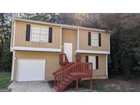 Inviting two-story home featuring tan siding, black shutters, and stairs to a covered front porch at 5300 Forest Downs Ln, Atlanta, GA 30349