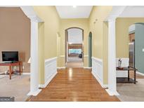 Bright foyer featuring hardwood floors, archways, and decorative white molding, leading to other rooms at 4424 Bellwood Cir, Atlanta, GA 30349