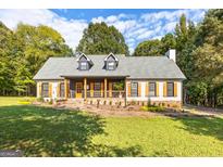 Charming farmhouse exterior with white siding, gray roof, and stone walkway at 4392 Lower Fayetteville Rd, Sharpsburg, GA 30277