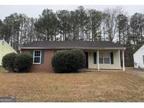 Brick ranch home with a well-maintained lawn and landscaping at 5575 Pine Gate Dr, Atlanta, GA 30349
