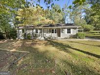 Charming single-story home with a well-maintained front yard and a welcoming entrance, nestled among mature trees at 1963 Suwanee Ter, Lawrenceville, GA 30043