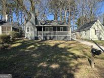 Charming home with a inviting front porch, lush green lawn and mature trees at 1457 Richland Sw Rd, Atlanta, GA 30310