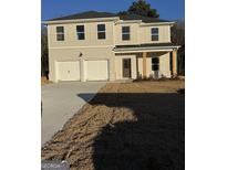 A charming two-story home featuring a brick and siding exterior with a two-car garage and a well-maintained front yard at 333 Orwell Dr # 51, Social Circle, GA 30025