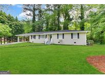 Charming single-story home features a large front lawn and a welcoming entryway with white stairs at 3086 Meadow Lark Ln, East Point, GA 30344