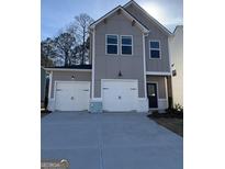 Charming two-story gray home with white trim, two-car garage, and modern black door at 209 Weldon Rd # 43, Mcdonough, GA 30253