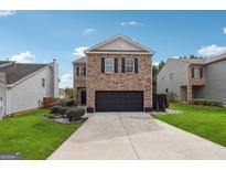 Two-story brick home with a black garage door and landscaped lawn at 5602 Waverly Park, Atlanta, GA 30349