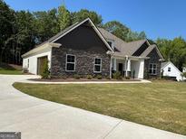 Beautiful stone and siding home with a manicured lawn and attached two car garage at 152 Wet Wood Dr # 10, Fairburn, GA 30213