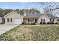 Charming home featuring manicured landscaping, a covered front porch, and a well-maintained lawn at 130 Nicki Ct, Hampton, GA 30228