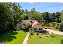 An attractive home features a manicured lawn and mature trees, offering a serene and private setting at 50 Persian Pl, Whitesburg, GA 30185