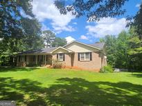 Charming brick home featuring a well-manicured lawn and a cozy front porch at 55 Gill Ln, Stockbridge, GA 30281