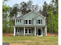 Two-story home featuring gray siding, black shutters, white trim, and a well-manicured lawn at 1555 South Bethany Rd, Locust Grove, GA 30248