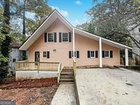 Charming A-frame home with a spacious deck, black shutters, and inviting curb appeal at 4405 Cary Dr, Snellville, GA 30039