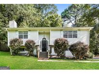 Charming home featuring manicured lawn and black front door with palladian window at 2636 Suzanne Ln, Acworth, GA 30102