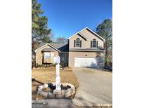 Charming two-story home featuring a two-car garage, manicured lawn, and traditional architectural details at 4284 Caroline Ct, Douglasville, GA 30135