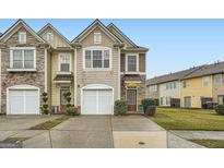Charming townhome showcases a well-manicured lawn, a one-car garage, and a welcoming entrance at 1963 Lakeshore Overlook Nw Cir, Kennesaw, GA 30152