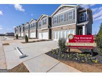 Row of new townhomes with gray siding, brick accents, and attached garages on a sunny day at 11517 Kimberly Way # 3, Hampton, GA 30228