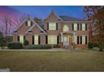 Charming two-story brick home with black shutters and a well-manicured lawn and front yard at 355 Woodbyne Dr, Fayetteville, GA 30214
