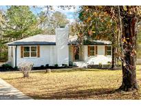 Newly renovated ranch home with white brick exterior and landscaped yard at 32 Collins Rd, Locust Grove, GA 30248