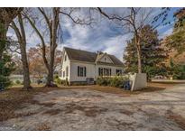 Classic two-story home featuring a spacious parking area and mature trees in a quiet neighborhood at 3810 2Nd Ave, Mansfield, GA 30055