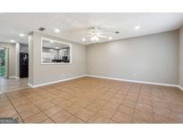 Spacious living room with ceiling fan and a view to the kitchen through an opening at 8227 Englewood Trl, Riverdale, GA 30274