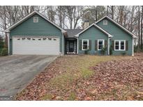 Charming single-story home featuring a two-car garage and manicured front yard with a walkway to the front door at 2744 Amber Springs Way, Buford, GA 30519