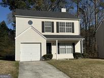 Charming two-story home featuring a garage, black shutters and trim, and a well-maintained front yard at 6409 Guinness Ct, Union City, GA 30291