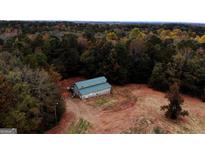 Aerial view of a barn-style building on a large lot with wooded area at 5300 Salem Rd, Covington, GA 30016