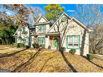 Two-story house with green accents and stonework, nestled amongst trees at 232 Terrane Rdg, Peachtree City, GA 30269