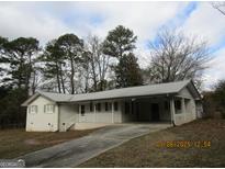 Ranch-style home with carport and mature trees at 423 Center Sw Cir, Conyers, GA 30094