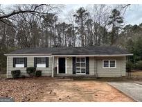 Charming one-story home with neutral siding, black shutters, and a well-maintained front yard at 1471 Cedar Creek Ln, Riverdale, GA 30296