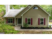 Charming single-story home with a manicured lawn, tan siding, and contrasting red shutters at 65 Riverside Way, Sharpsburg, GA 30277